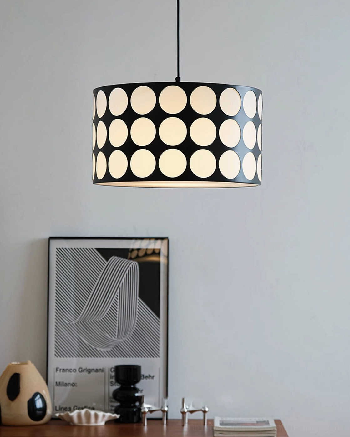Polka dot pendant lamp hanging in minimalist interior with retro table decor and vintage art poster