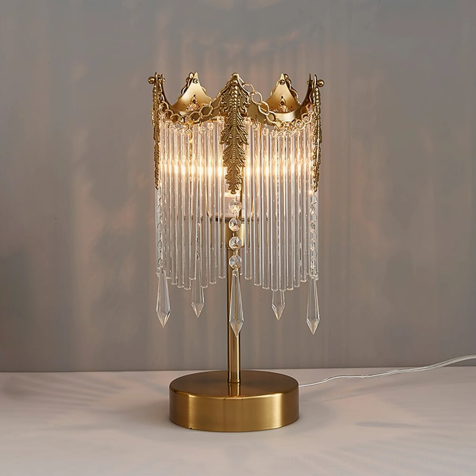 Illuminated Popity table lamp showing warm light refraction through crystal strands and polished brass accents