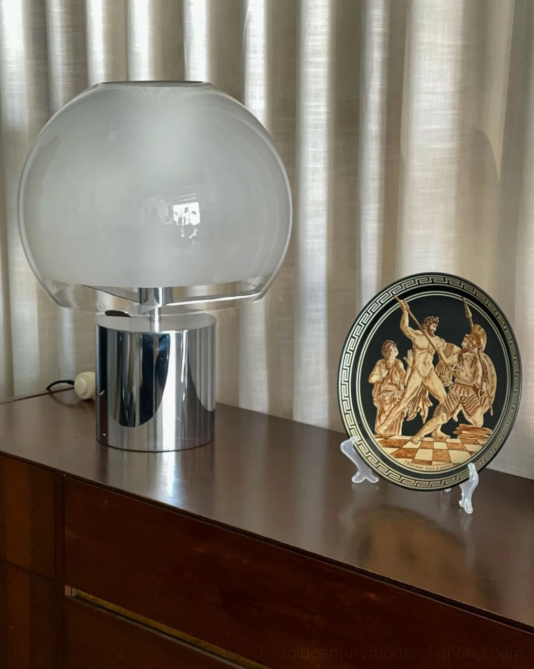 Porcino table lamp with textured frosted glass and polished chrome base on vintage wooden sideboard with classical decorative plate