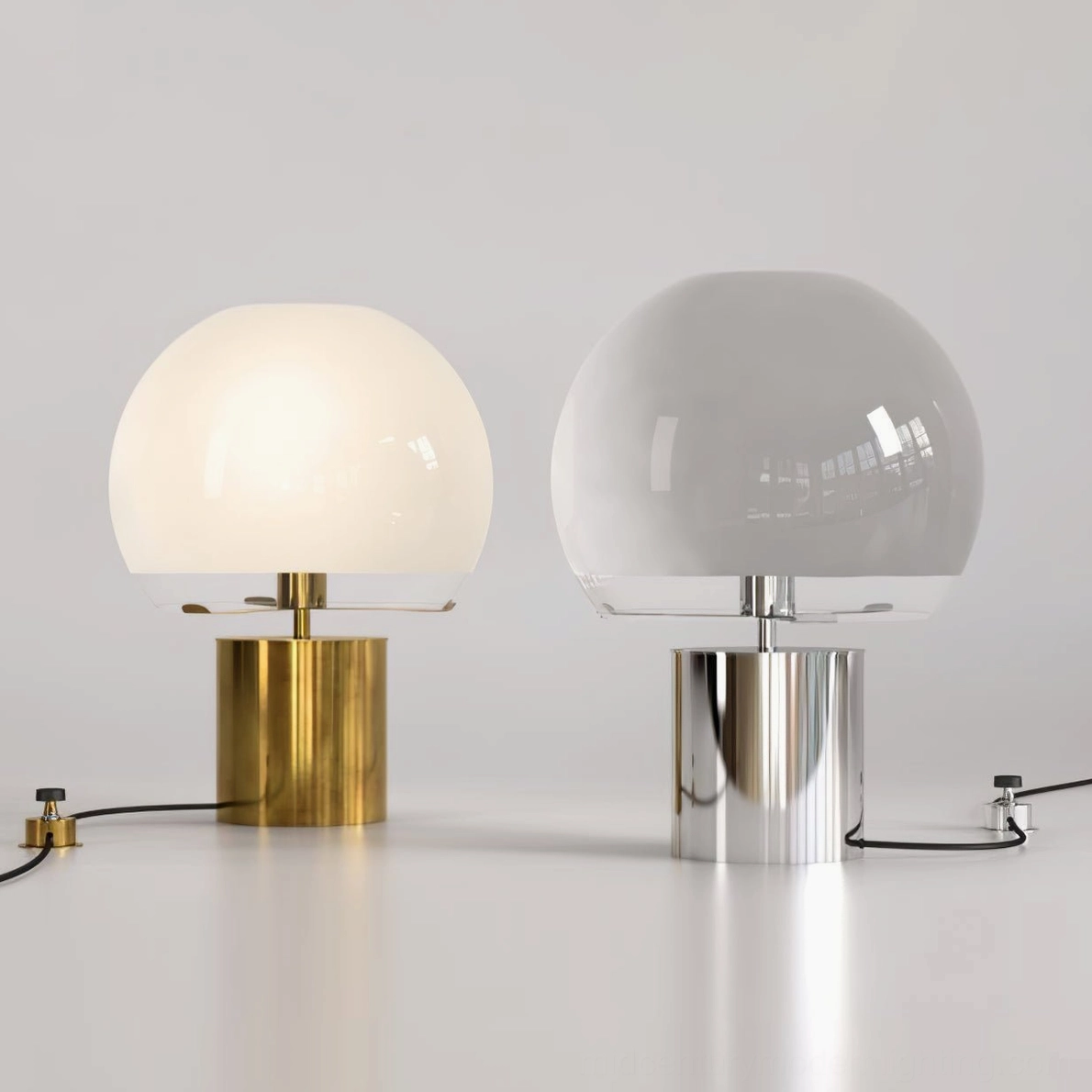 Pair of Porcino mid-century modern table lamps in silver and gold finishes with different glass shades on minimalist white tabletop