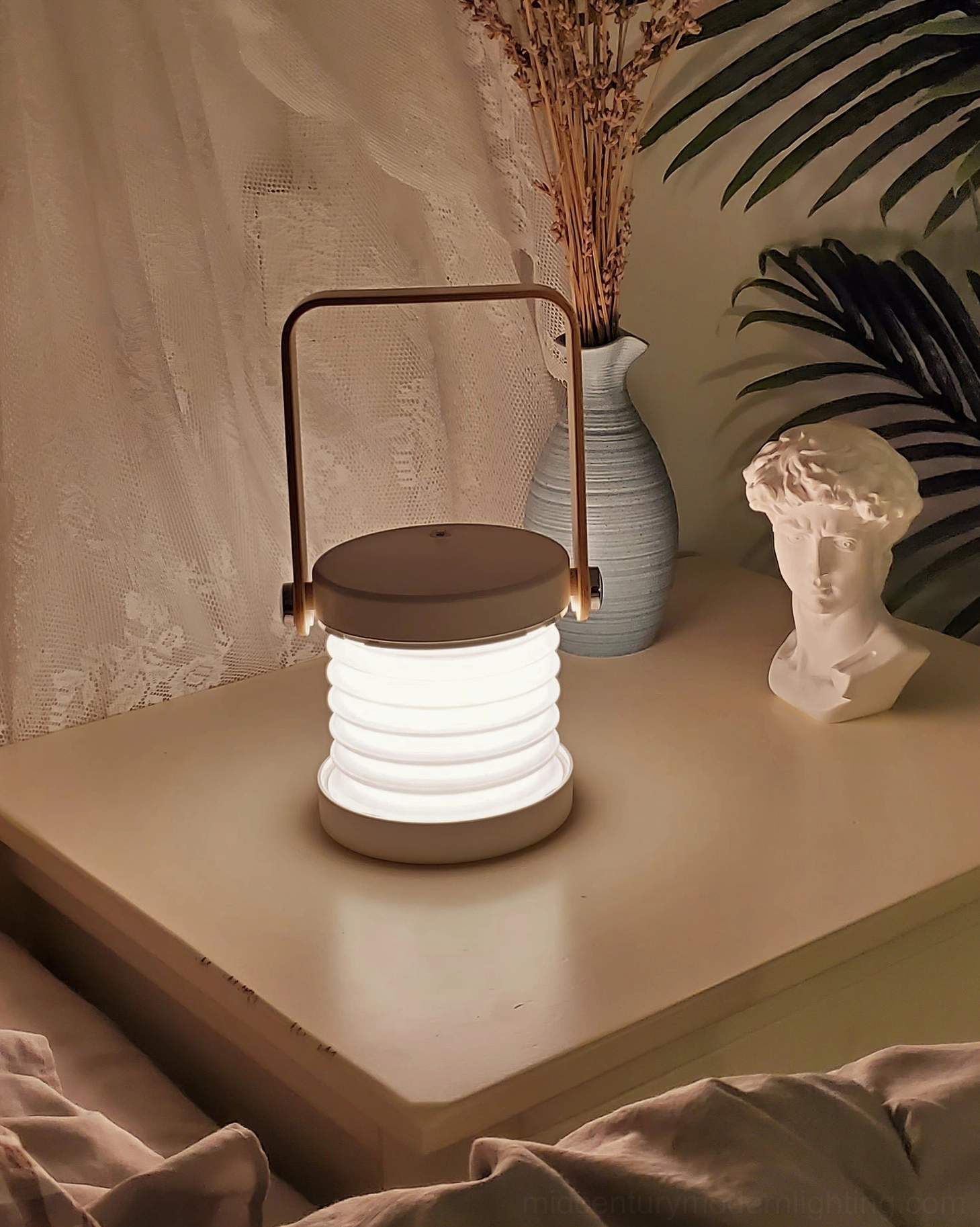 Portable lantern lamp in multiple color finishes displayed together, showcasing red wood and grey wood variants