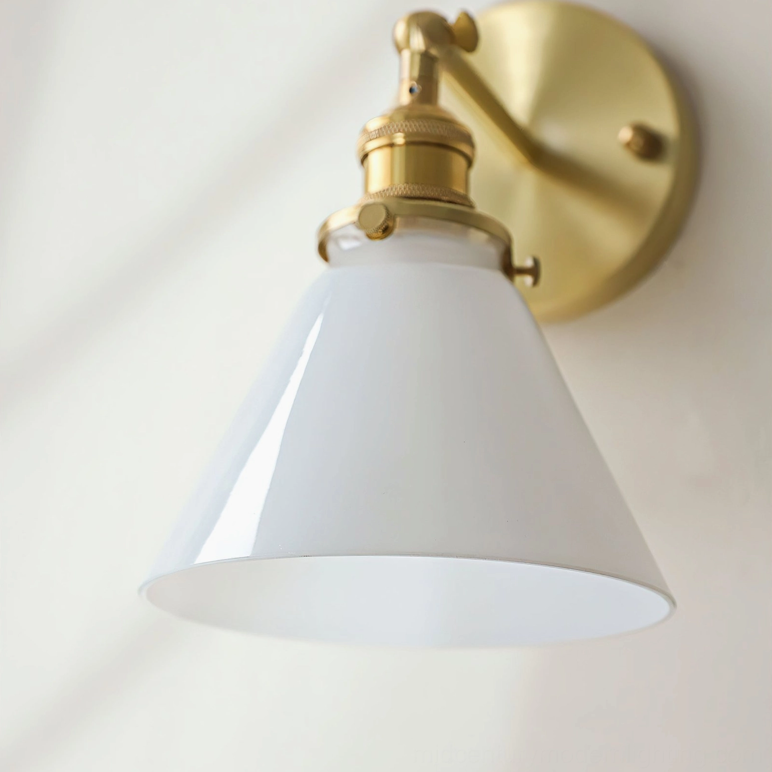 Portland wall sconce side view studio backdrop, matte white conical shade with brass metalwork retro styling