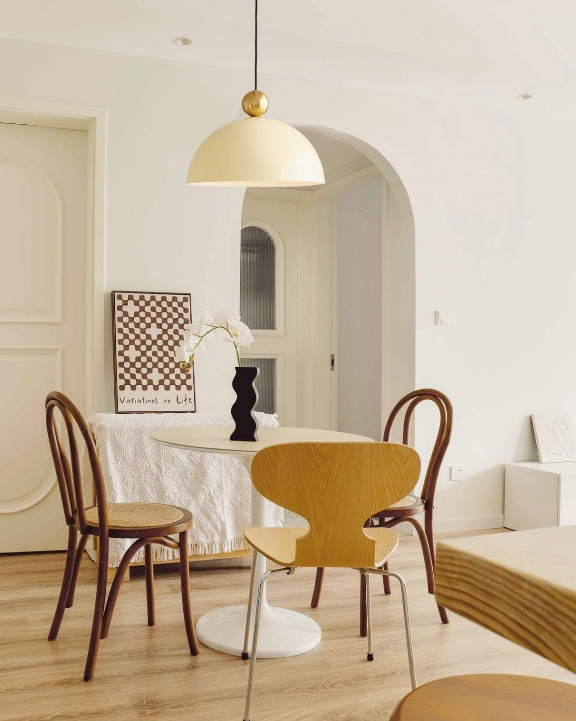 Cream white glossy dome pendant fixture in retro dining room with arched doorway