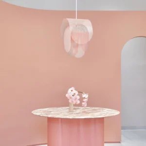 Posie pendant light in blush pink installed above dining table, soft pastel room setting