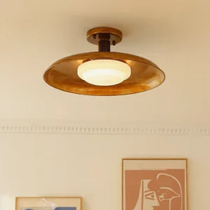 Illuminated mid-century pot-lid ceiling light installed in vintage-style interior room, warm ambient lighting from below