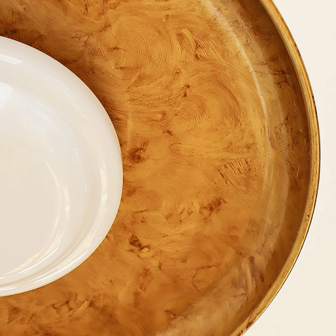Angled close-up detail of brass pot-lid shade and textured opal glass light diffuser