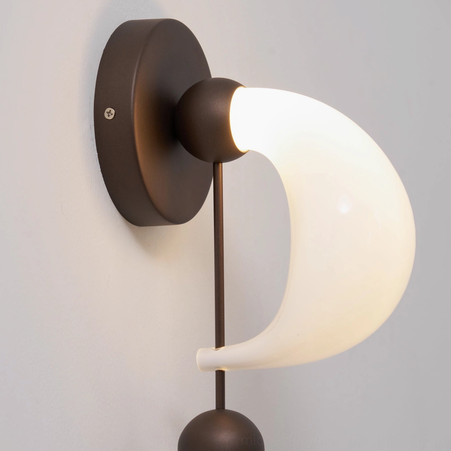 Premium bent glass wall sconce with hand-formed shade and sculptural brass framework, luxury interior lighting design