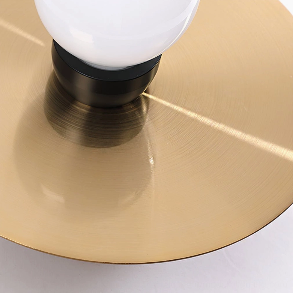 Close-up detail of frosted glass sphere and premium metal disc wall sconce construction