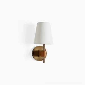 Prescot mid-century wall sconce with brushed brass base and hand-stitched tan leather accent, featuring tapered off-white fabric shade