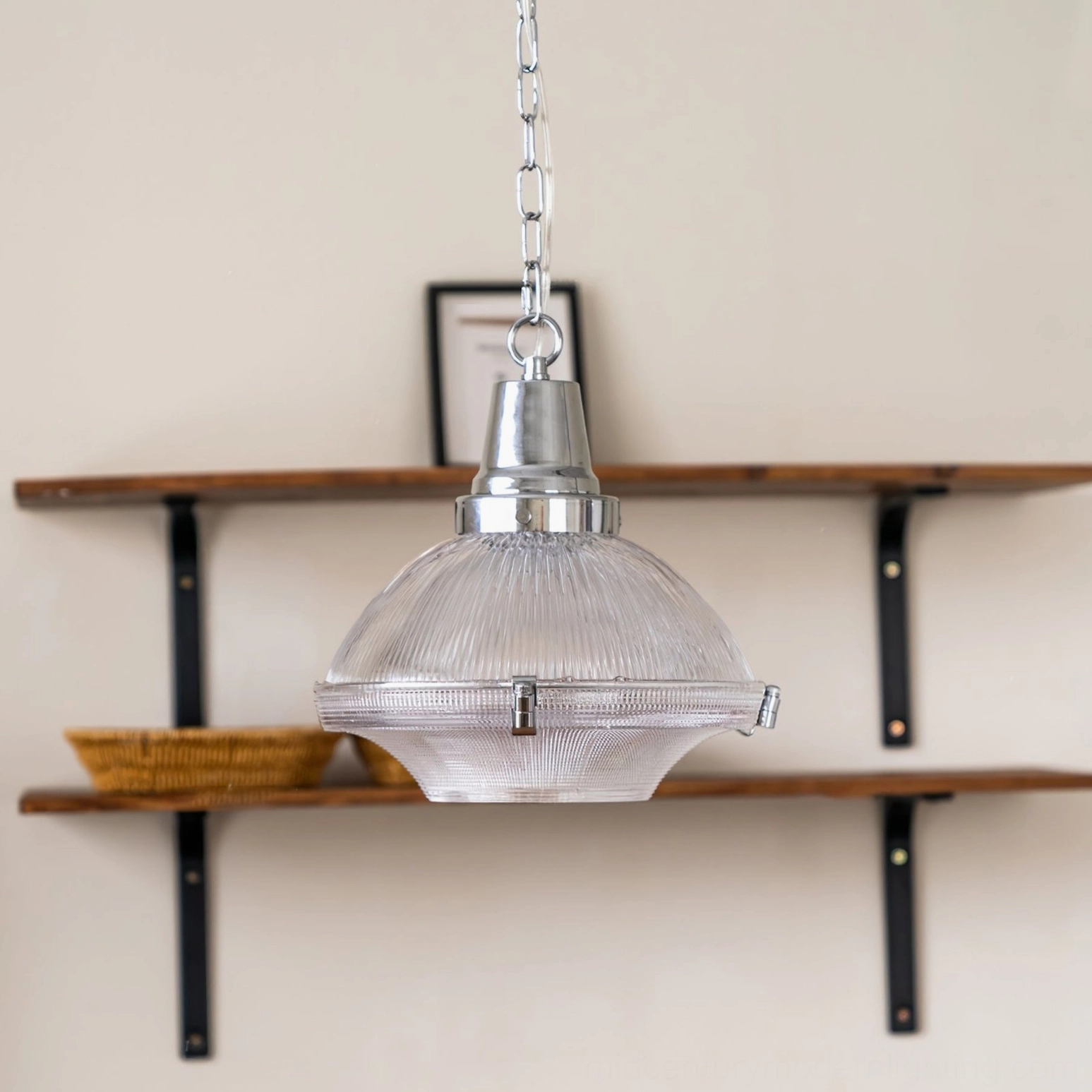 Clear ribbed glass pendant light with silver hardware displayed on double-tier wooden wall shelf