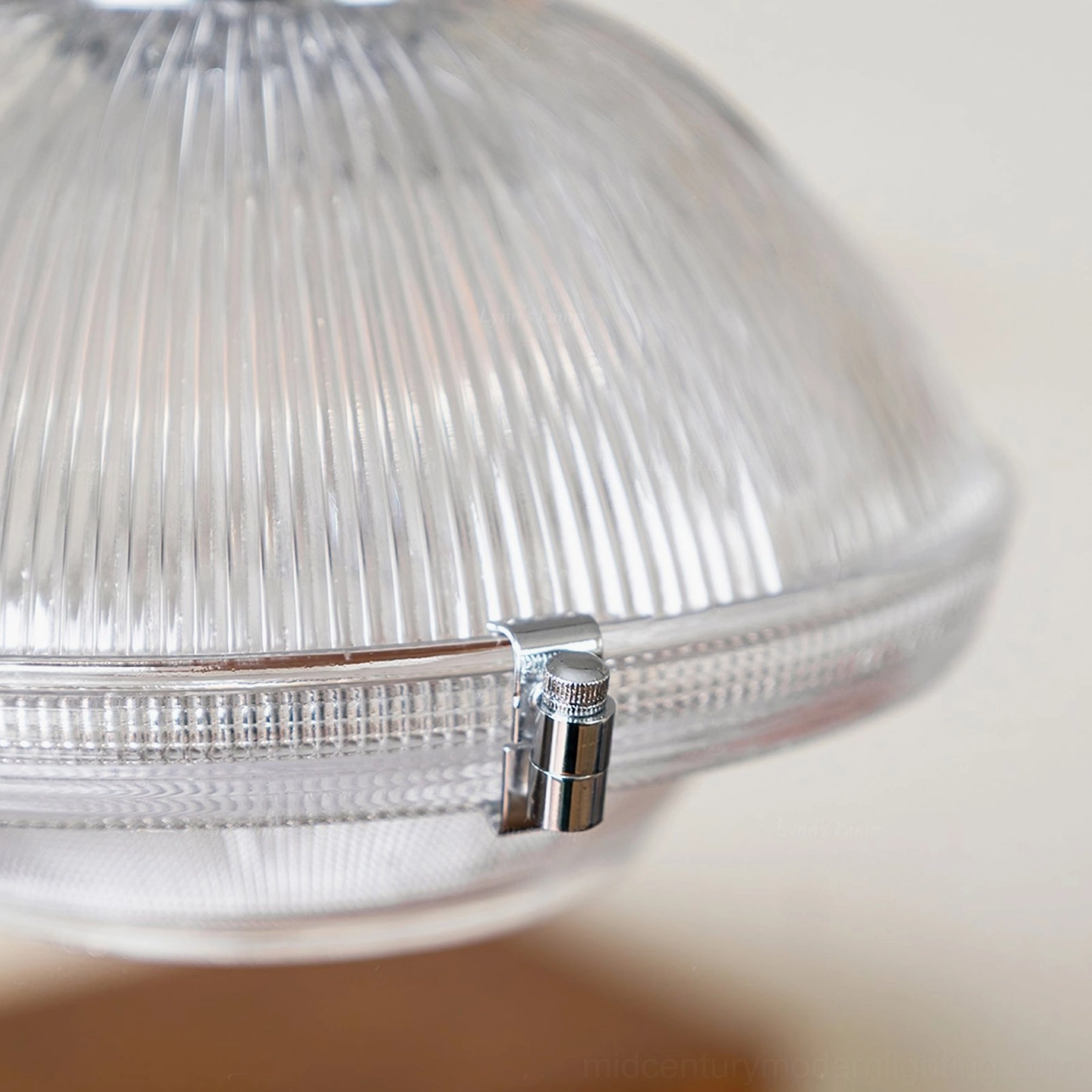 Close-up of vertical ribbed glass texture on prismatic pendant shade with chrome mounting clips