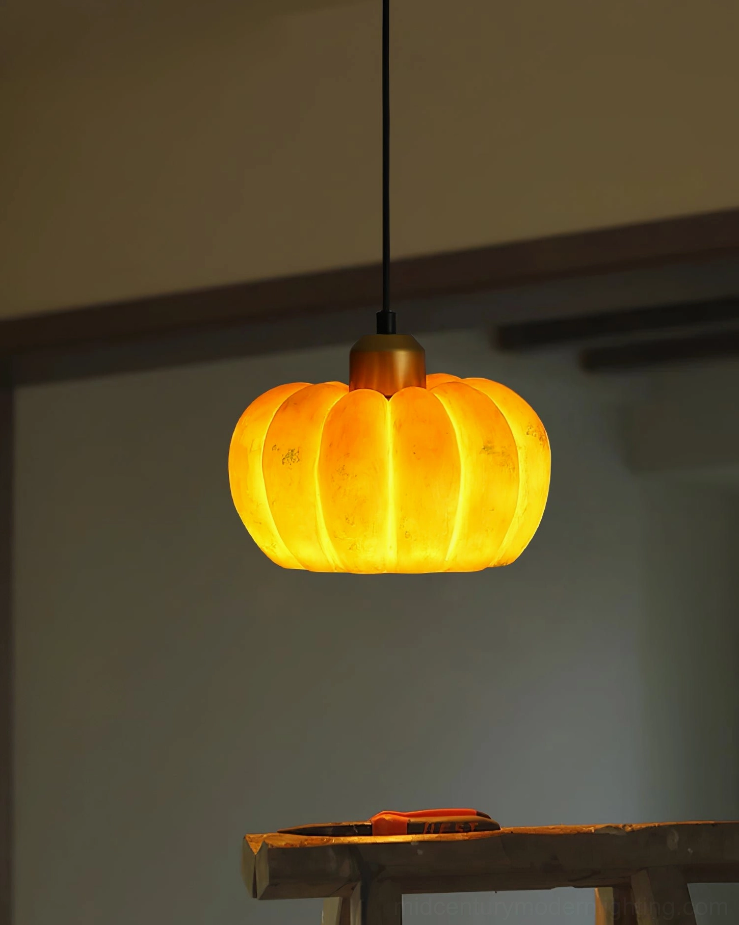 Pumpkin pendant lamp warm glow through ribbed texture creating soft diffused light pattern