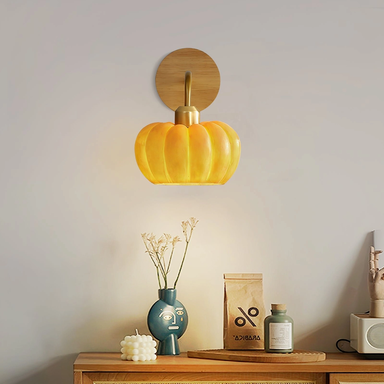 Pumpkin wall lamp illuminating vanity table corner with decorative objects and tabletop accessories, eye-level interior design styling