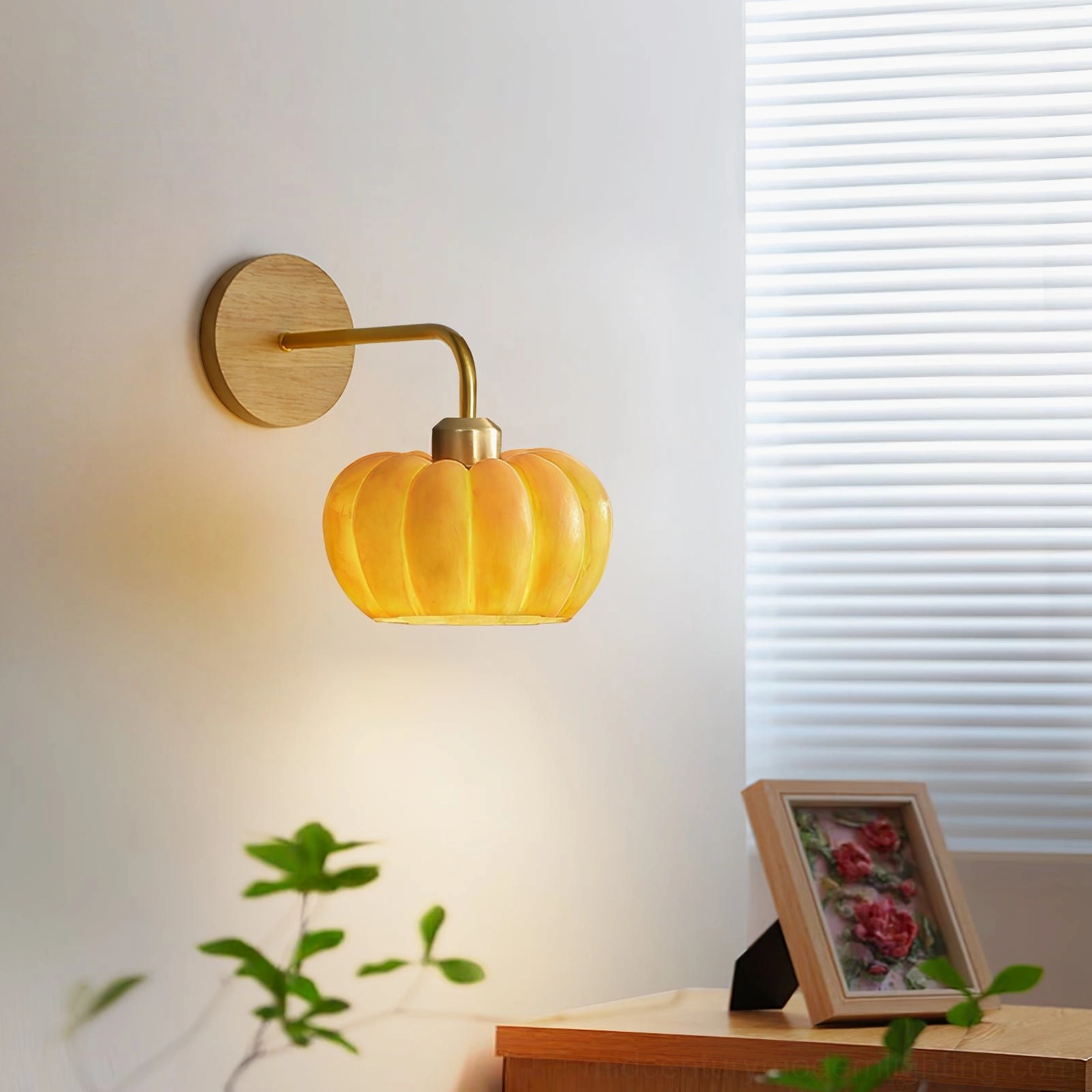 Pumpkin wall lamp mounted near louvered window with photo frame table decor, side eye-level interior perspective