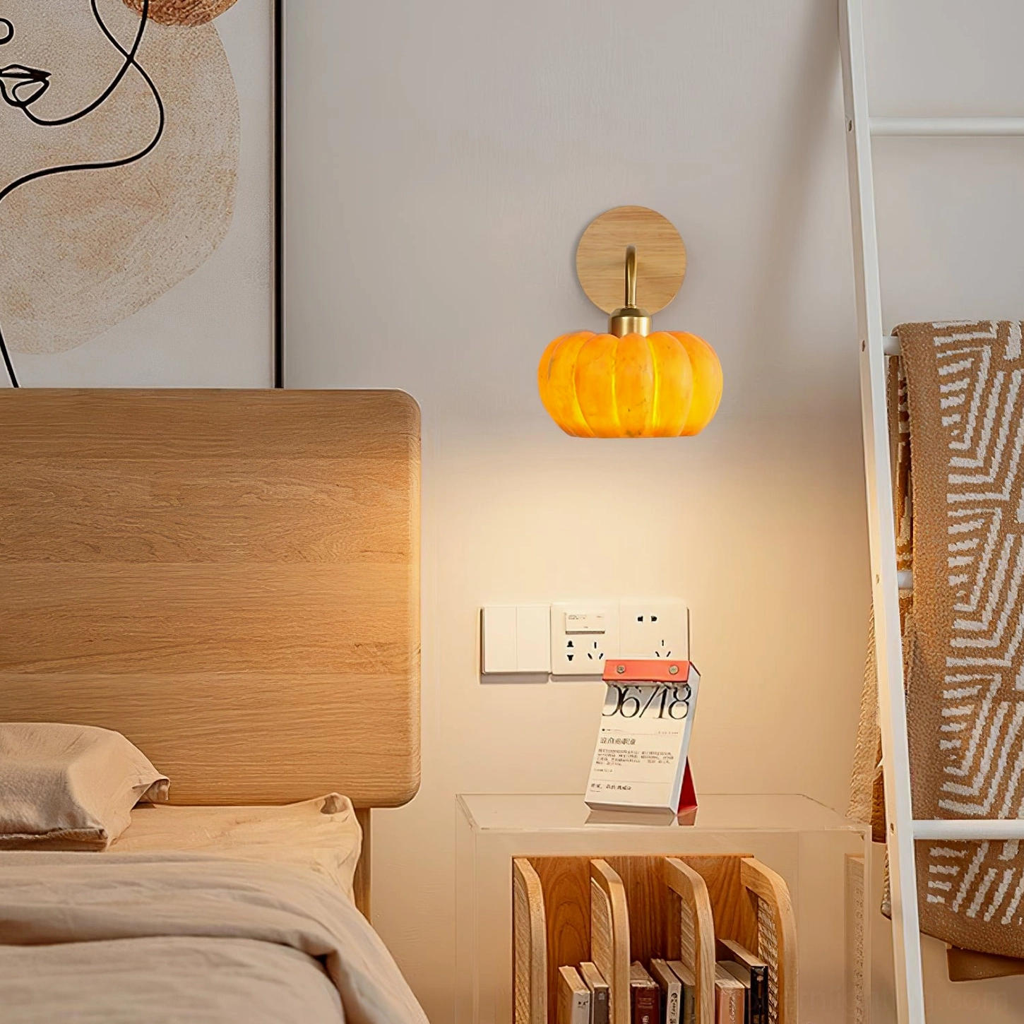 Pumpkin wall fixture above wooden bed with wall art and ladder storage rack, warm lighting in bedroom interior design