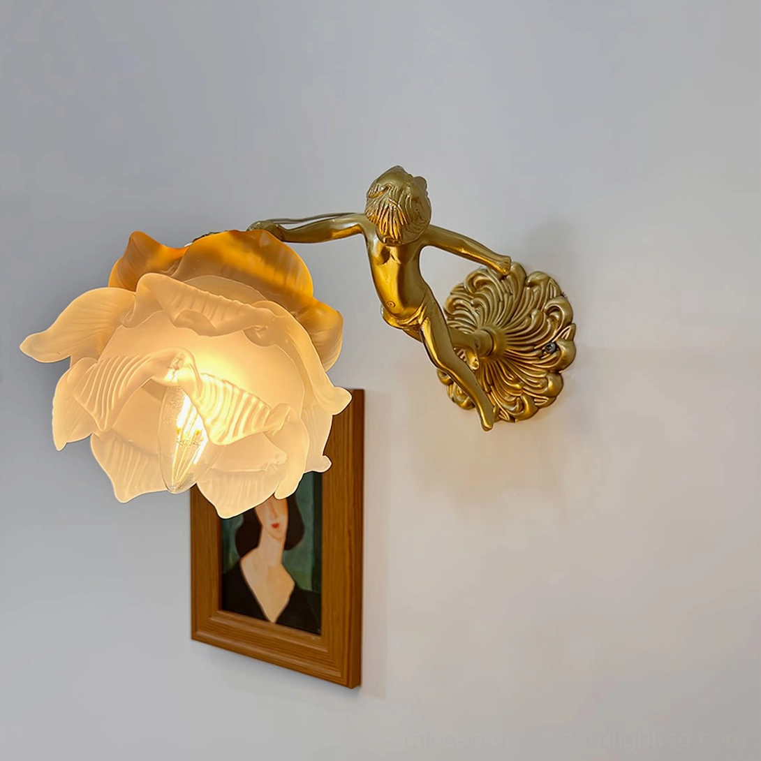 Putti cherub wall sconce illuminated on bedroom wall beside framed portrait, warm ambient light from frosted glass shade with brass accents