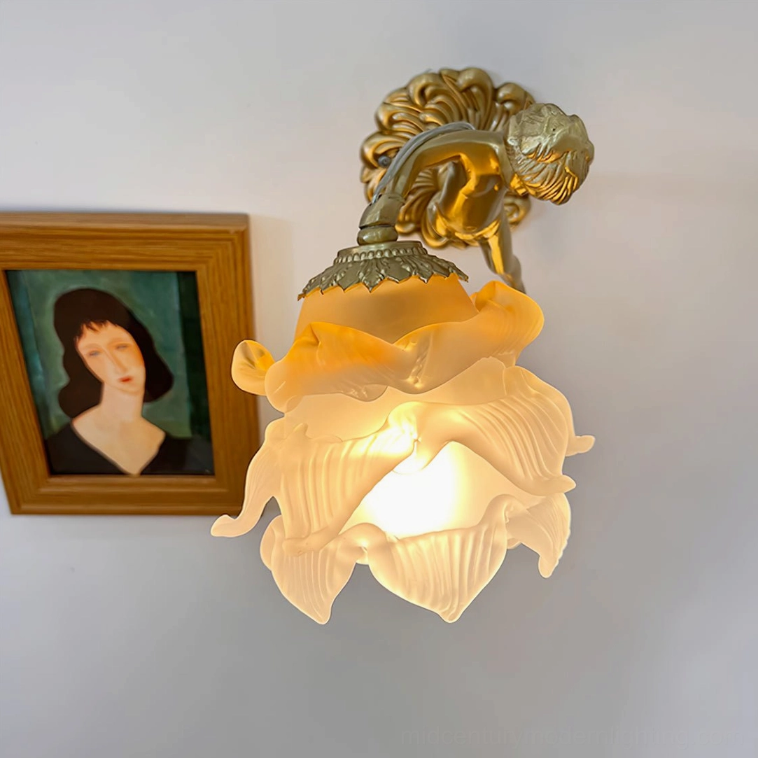 Putti wall lamp fixture top-down close-up view showing textured matte glass petal shade and ornate brass mounting base with sculptural detail