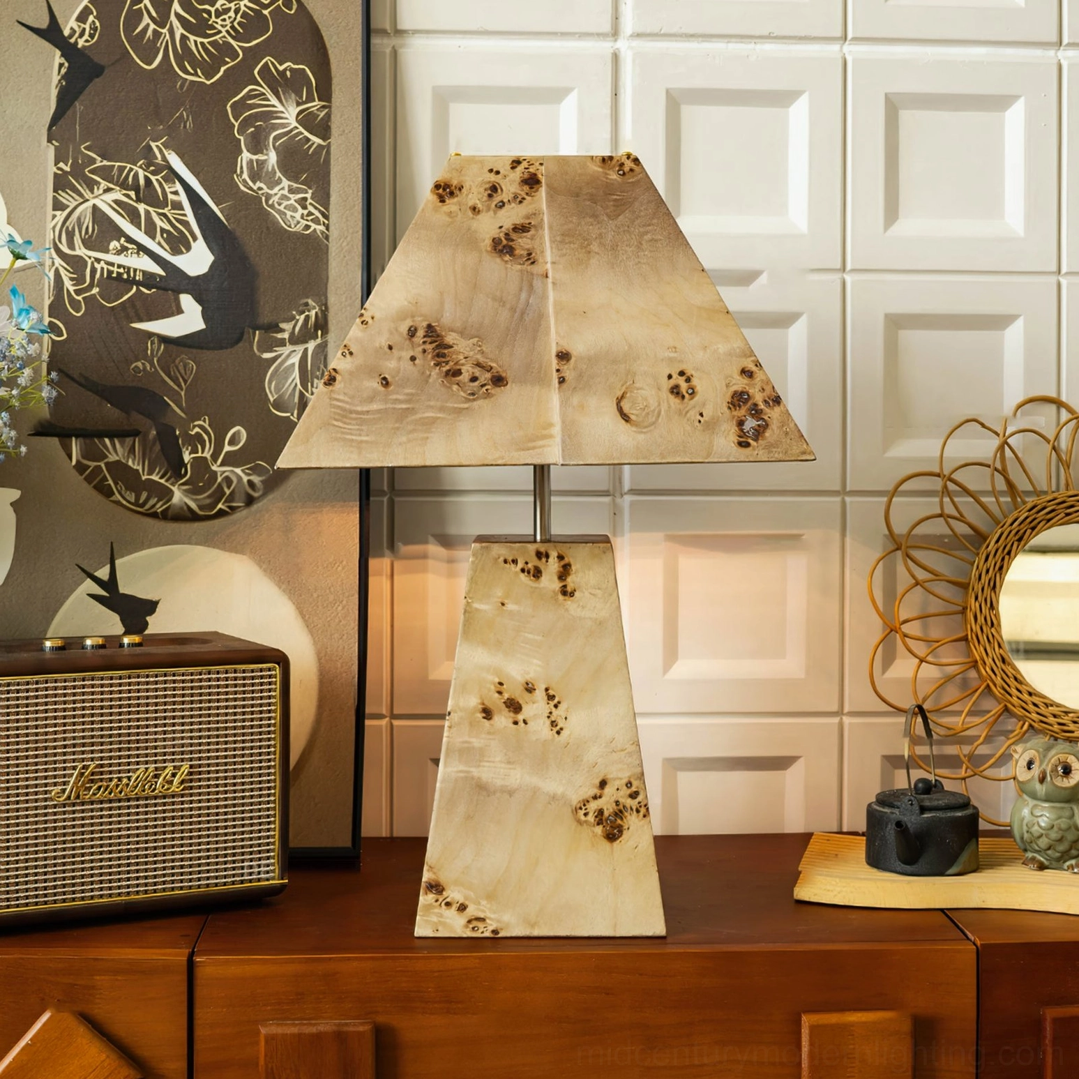 Tapered wood pyramid lamp staged with retro radio and woven wall mirror in mid-century modern room display