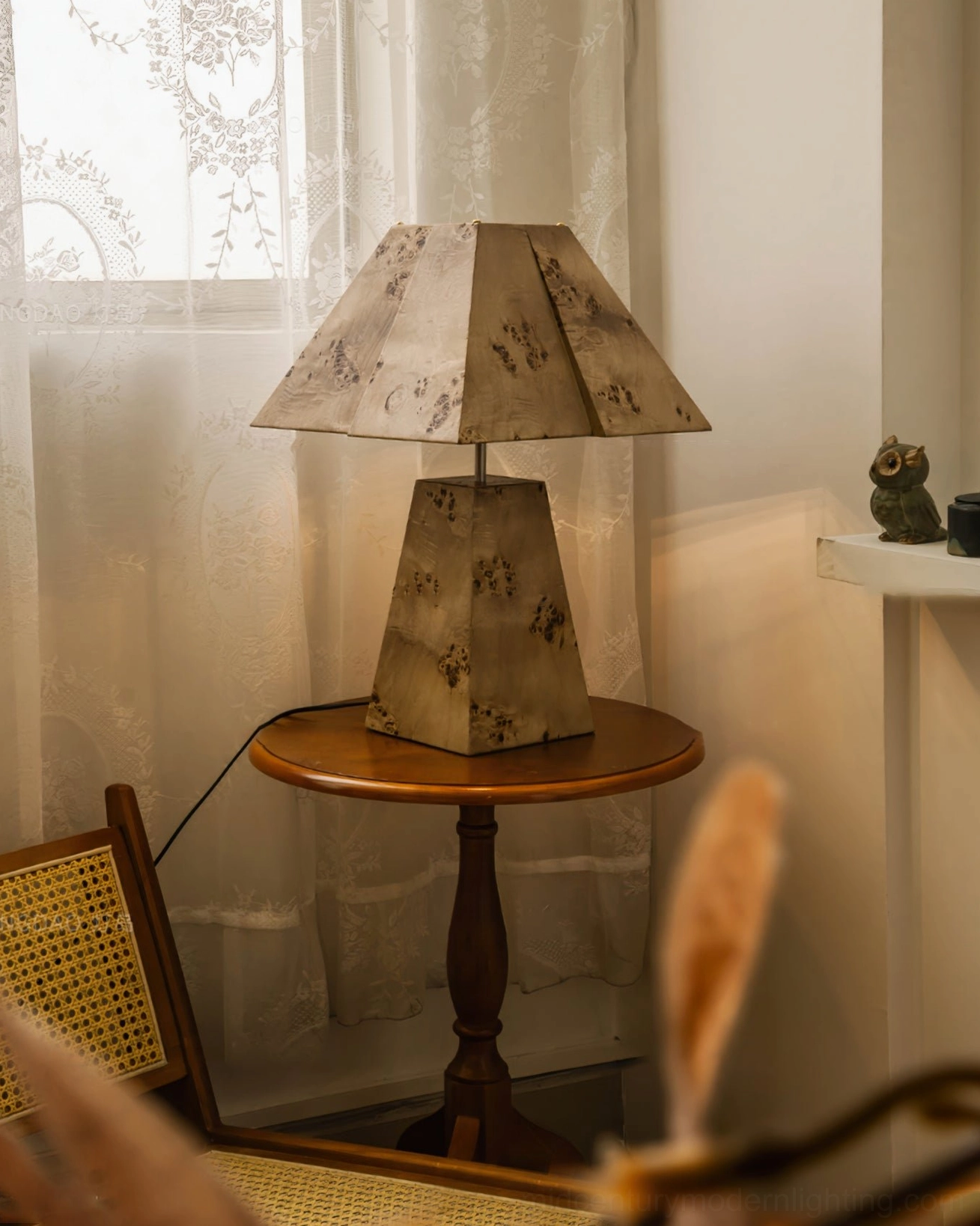 Natural wood pyramid table lamp displayed with vintage ceramic tea set and artwork in dining area corner