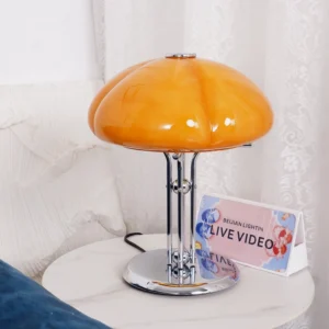 Quadrifoglio table lamp on marble bedroom nightstand, three-quarter front view showing warm amber glow and chrome stem