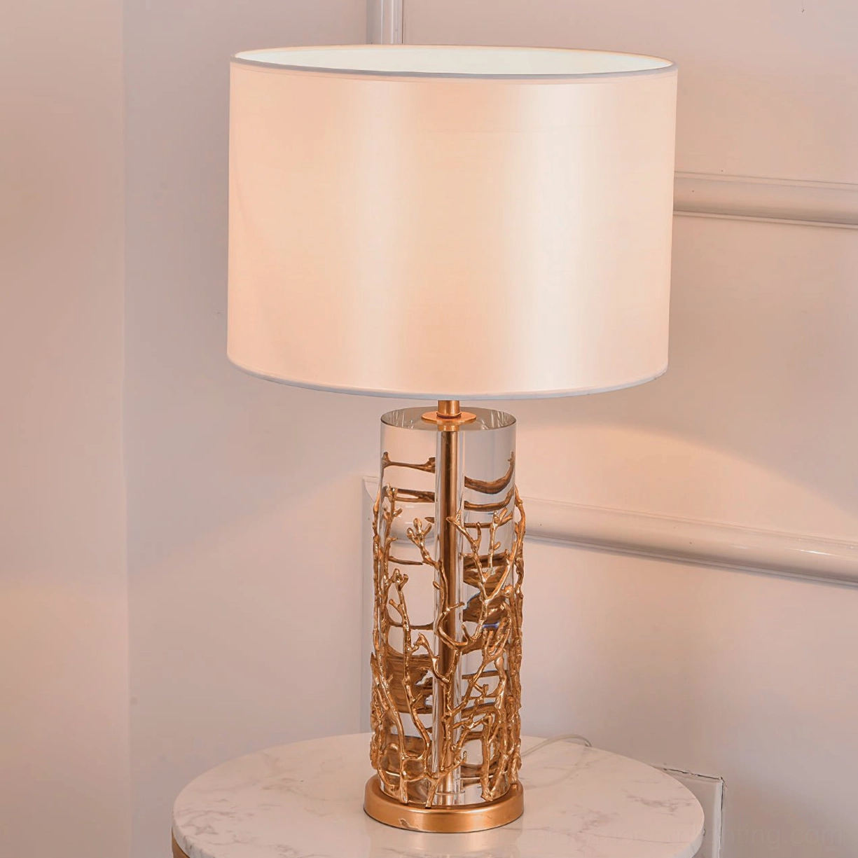 Quatrefoil table lamp with beige warm shade on marble table gold branch base luxury style