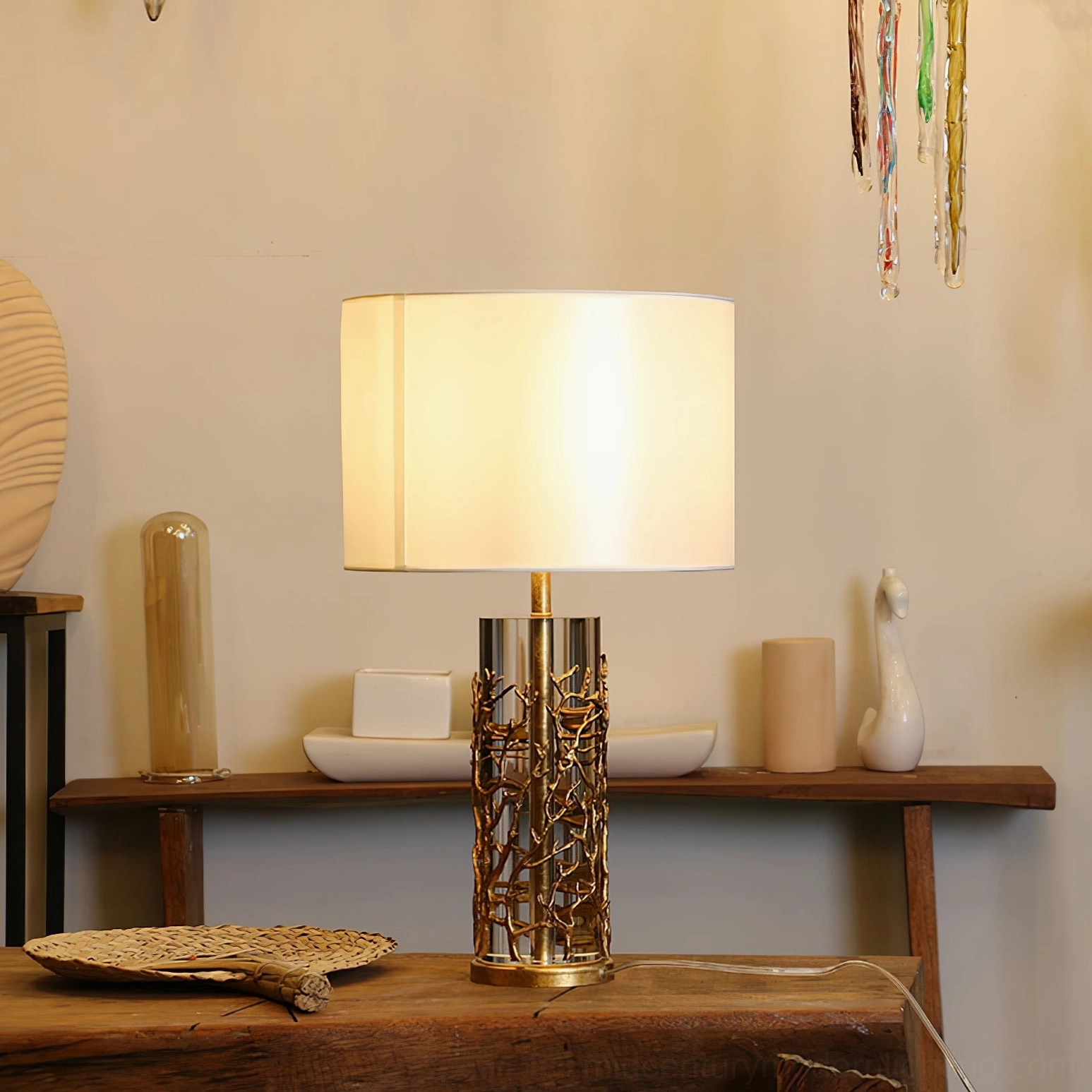 Lit quatrefoil table lamp on home shelf creating warm ambient lighting with brass crystal base details