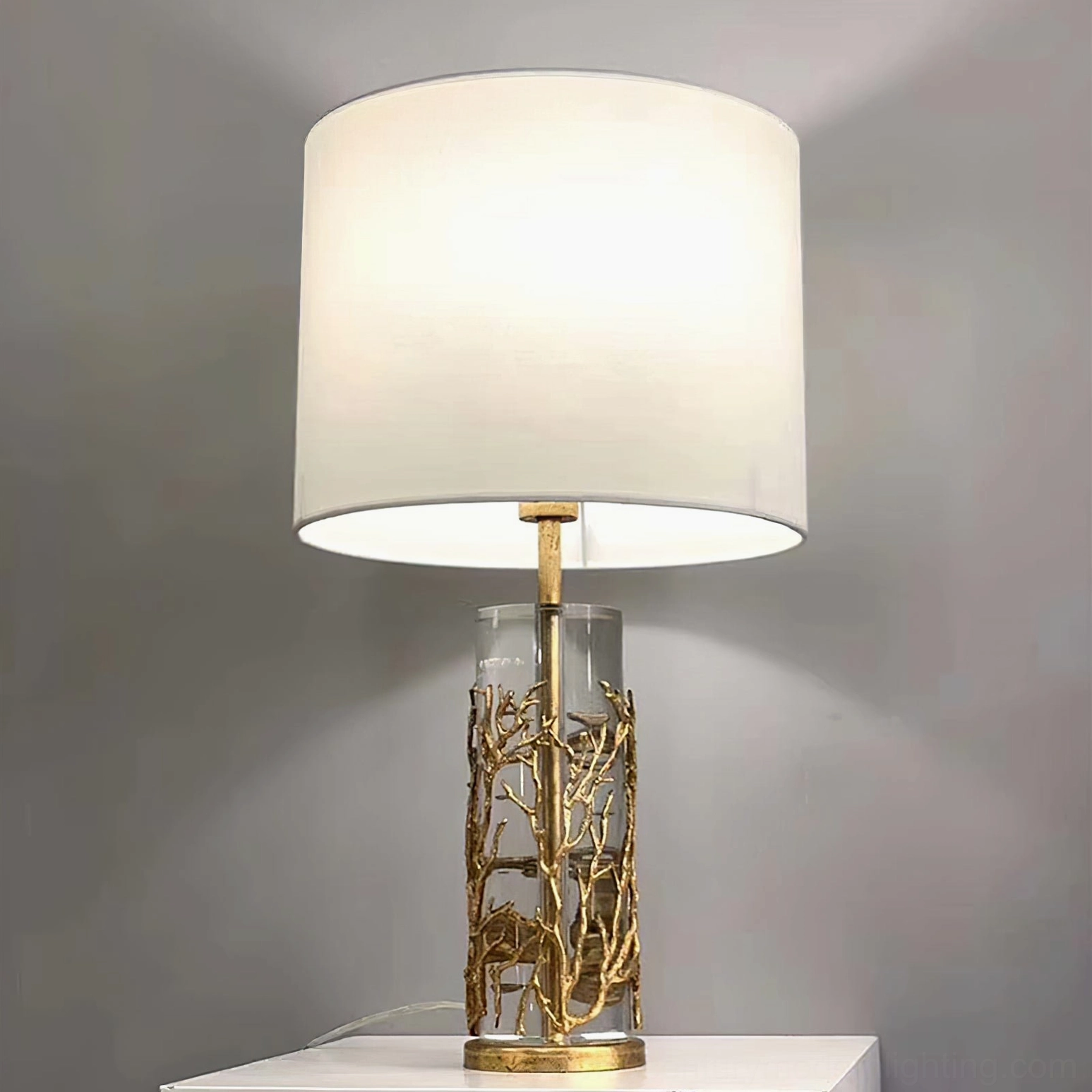 Modern quatrefoil table lamp with white shade and gold branch carved crystal base three-quarter view