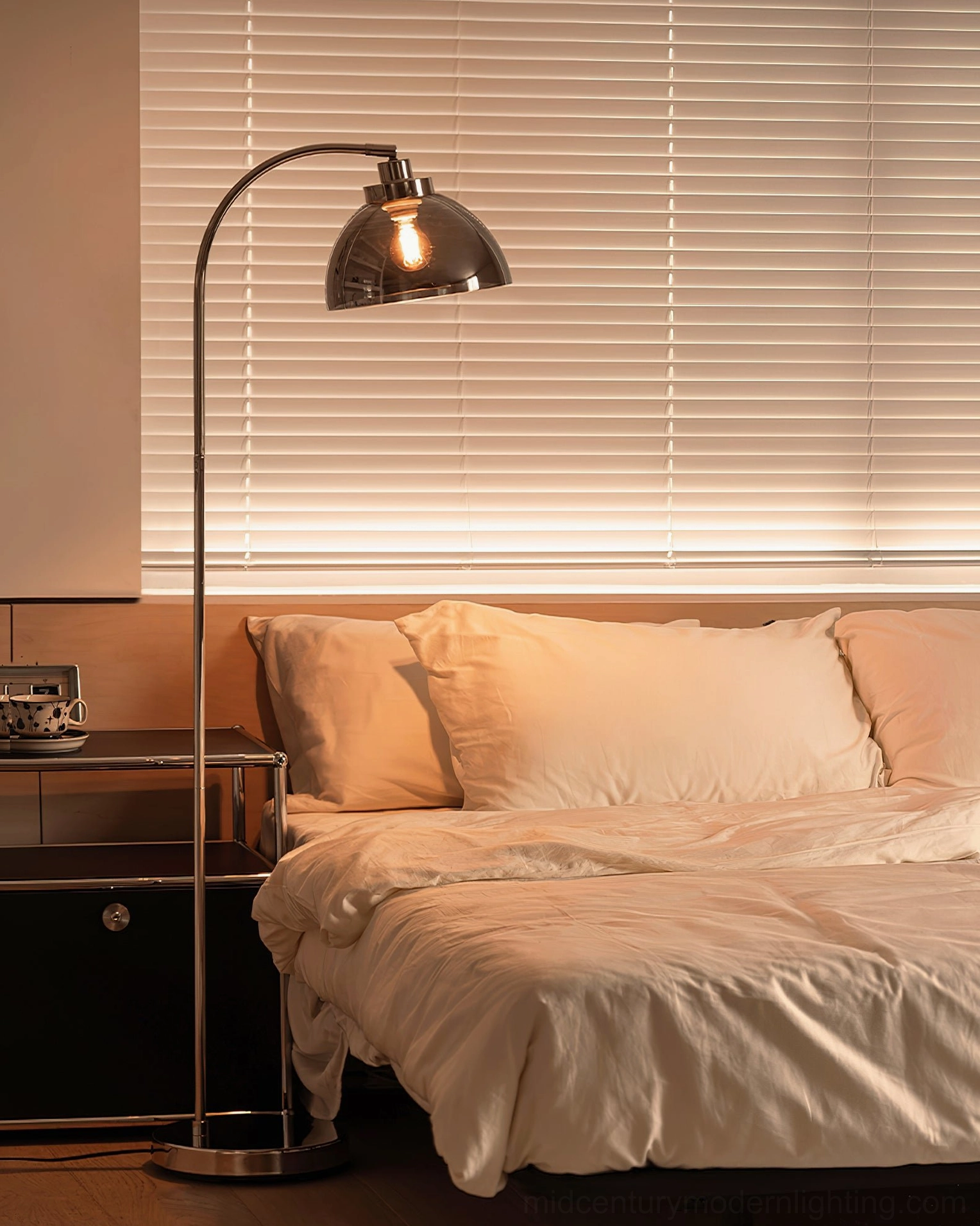 Arc floor lamp positioned in modern bedroom providing warm ambient bedside illumination
