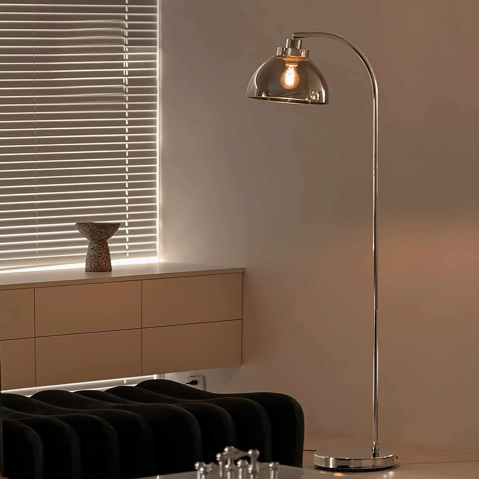 Contemporary arc floor lamp in modern minimalist home near window blinds and low storage cabinet