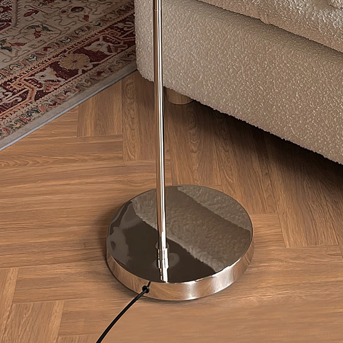 Ground-level view of Radcliff arc lamp base and polished chrome pole on herringbone wood flooring
