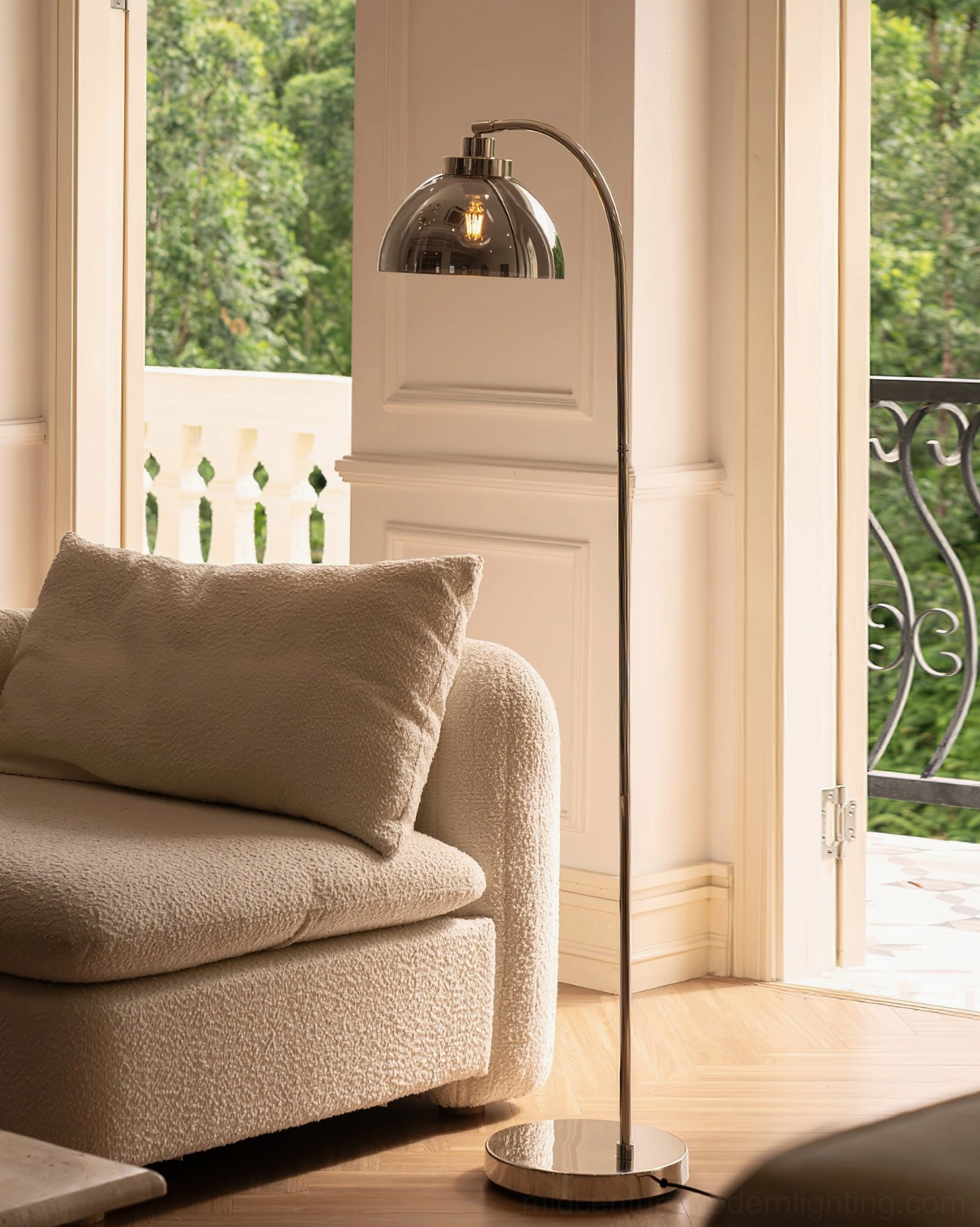 Contemporary arc floor lamp in sunlit living room with minimalist boucle seating and modern decor