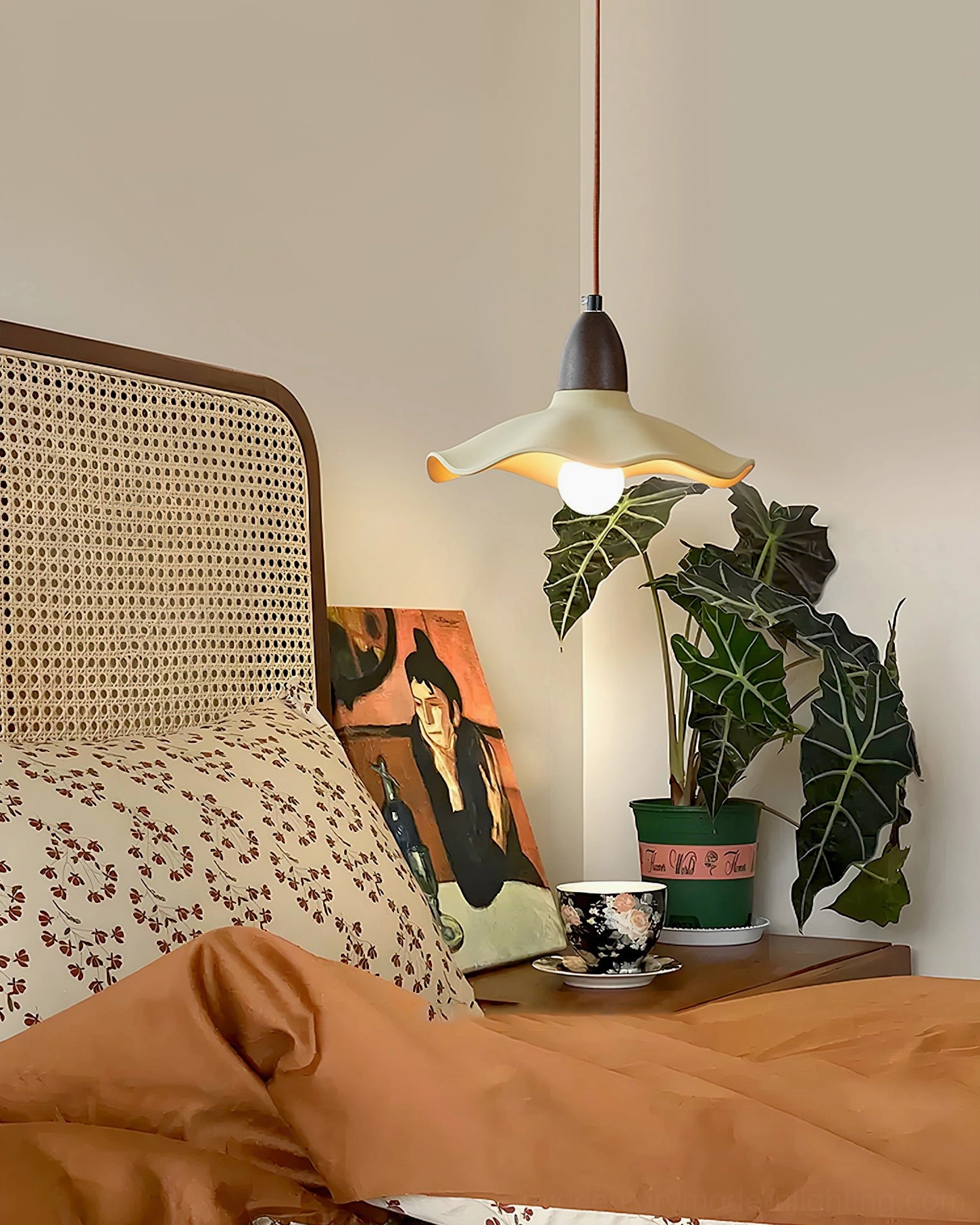 Radha pendant light casting soft ambient illumination in boho vintage bedroom with rattan headboard