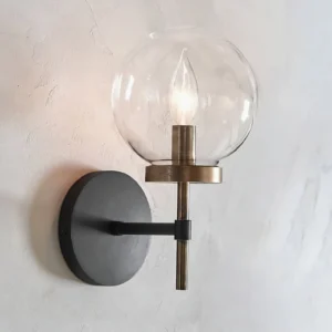 Ralbay illuminated globe wall light mounted on concrete wall with warm candlelight glow, close-up perspective