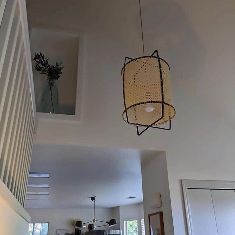 Rattan cane suspension light in contemporary bohemian interior, demonstrating warm ambient glow and sculptural presence above seating area