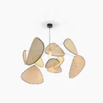 Handwoven rattan cluster pendant light with organic triangular shades and black metal frame, studio overhead view