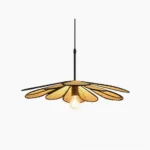 Handwoven rattan flower pendant light with black metal frame, studio view showing sculptural petal design and warm Edison bulb
