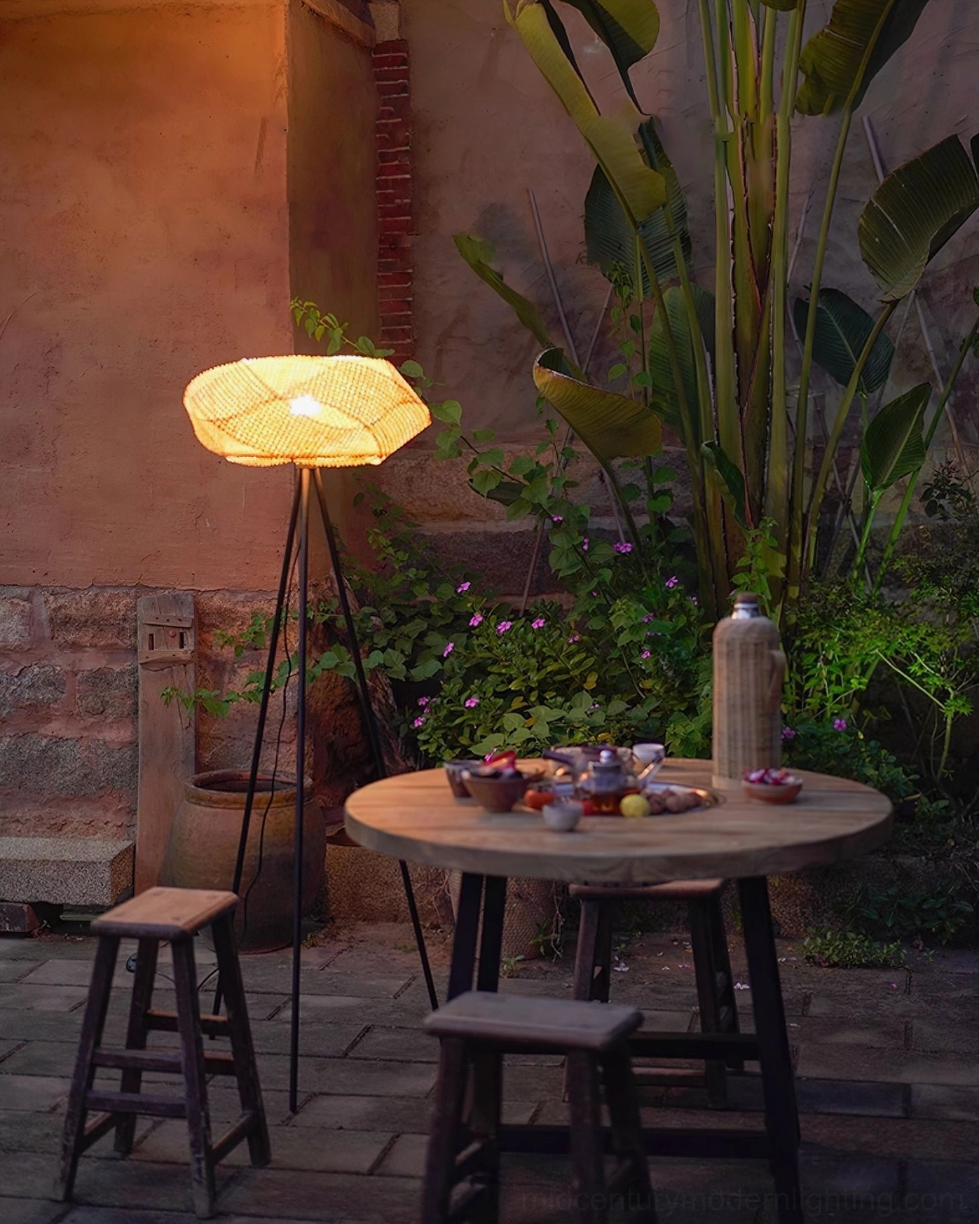Rattan tripod floor lamp paired with coastal modern decor elements and natural wood furniture, light airy aesthetic