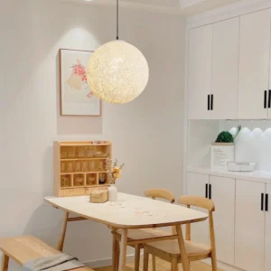 Wicker globe pendant light above dining table warm farmhouse interior lighting