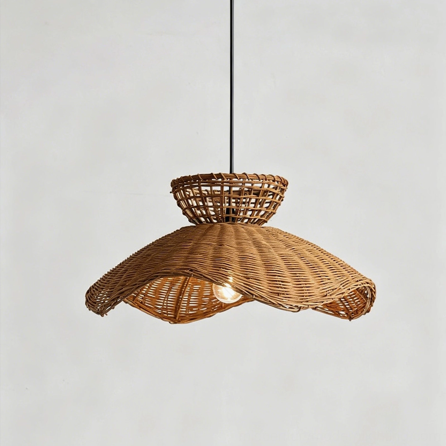 Three-quarter view of woven rattan pendant lamp showing basket weave structure and exposed LED bulb inside