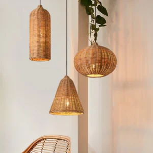 Hand-woven rattan pendant lights hanging in modern home interior with green plant, close-up view of three distinct woven shade geometries