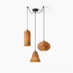 Three-shade hand-woven rattan pendant light set with black metal hardware, studio view showing cylindrical, conical, and spherical woven designs