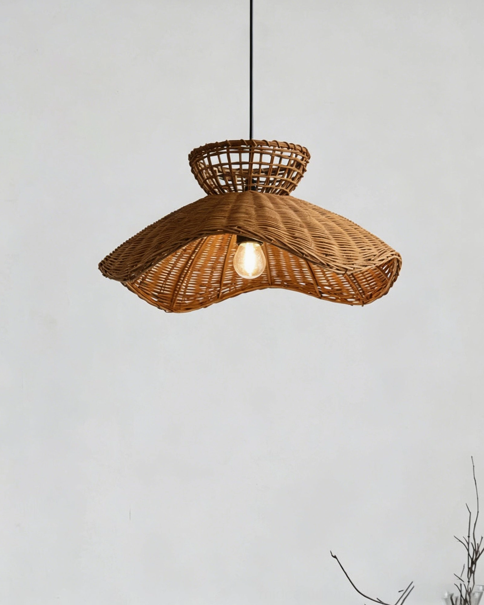 Close-up overhead view of rattan pendant showing intricate basket weave and exposed bulb socket
