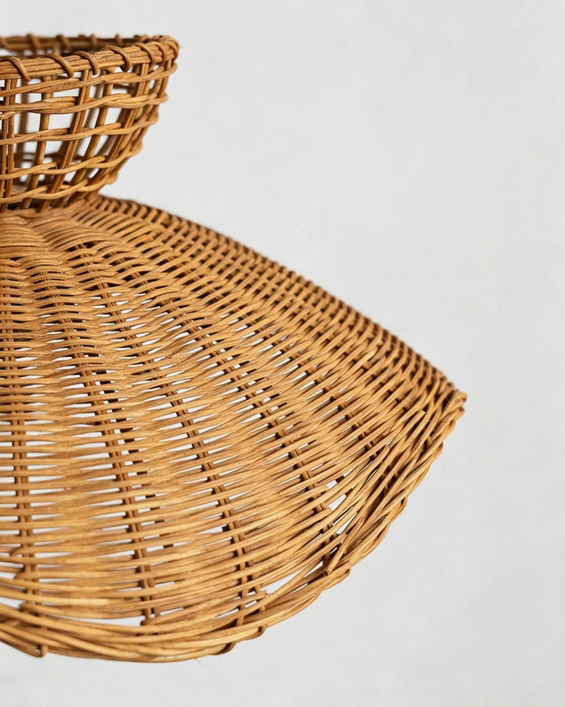 Close-up side angle of handwoven rattan lampshade highlighting fine texture and scalloped wavy edge