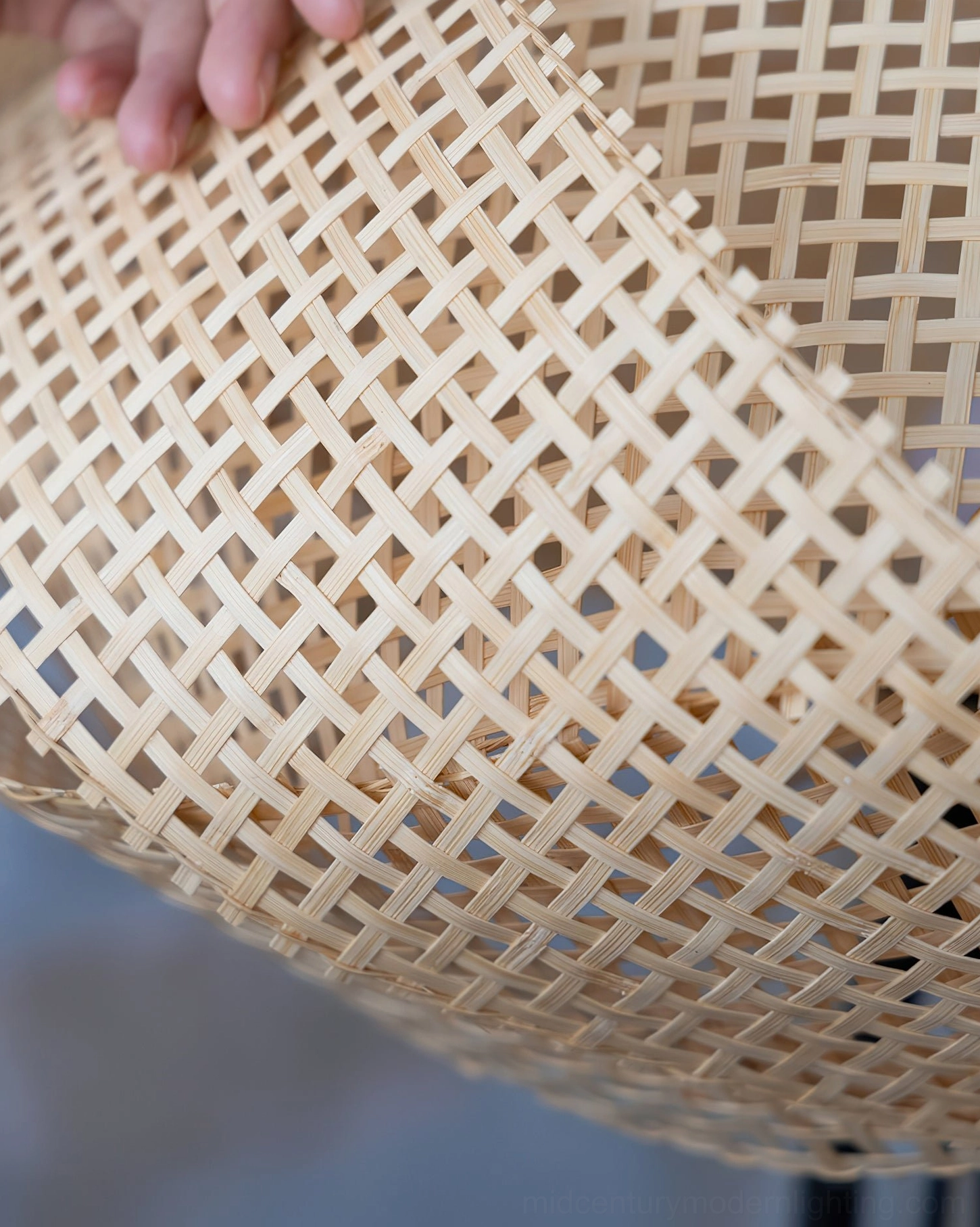 Natural woven rattan floor lamp with black metal frame creating warm diffused lighting in contemporary retail boutique setting