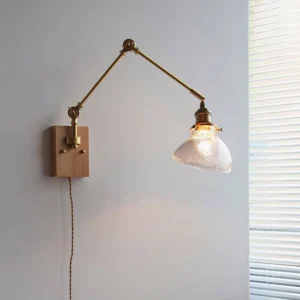 Rebell swing arm wall lamp with light wood base and clear ribbed glass shade, home interior side view with window blinds