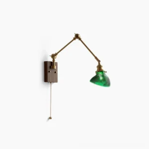 Rebell swing arm wall lamp front view with green ribbed glass shade, walnut wood base and polished brass arms on white background
