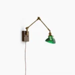 Rebell swing arm plug-in wall lamp with dark wood base and green ribbed glass shade, front studio view on white background