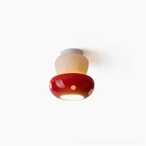 Red mushroom ceiling light with glossy ceramic cap and textured stem, front view on white background