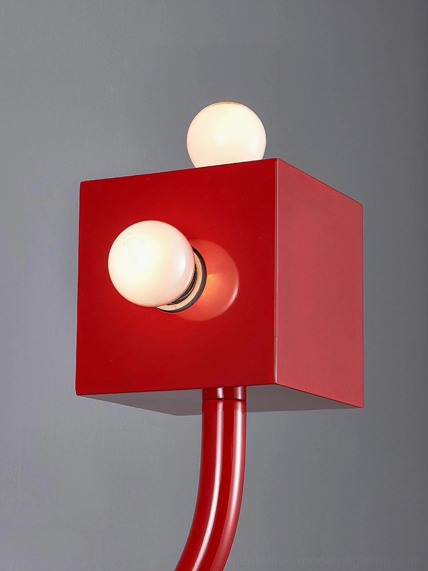 Red cube wall lamp close-up detail exposed bulb sockets dark background