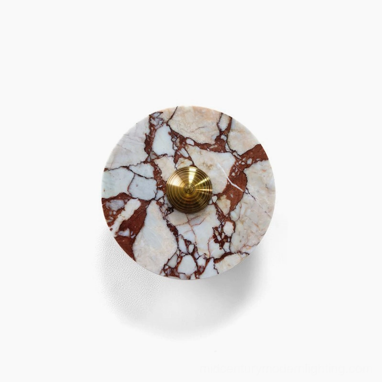 Red and white marble wall lamp with brass metalwork showing warm stone tones and luxury material quality